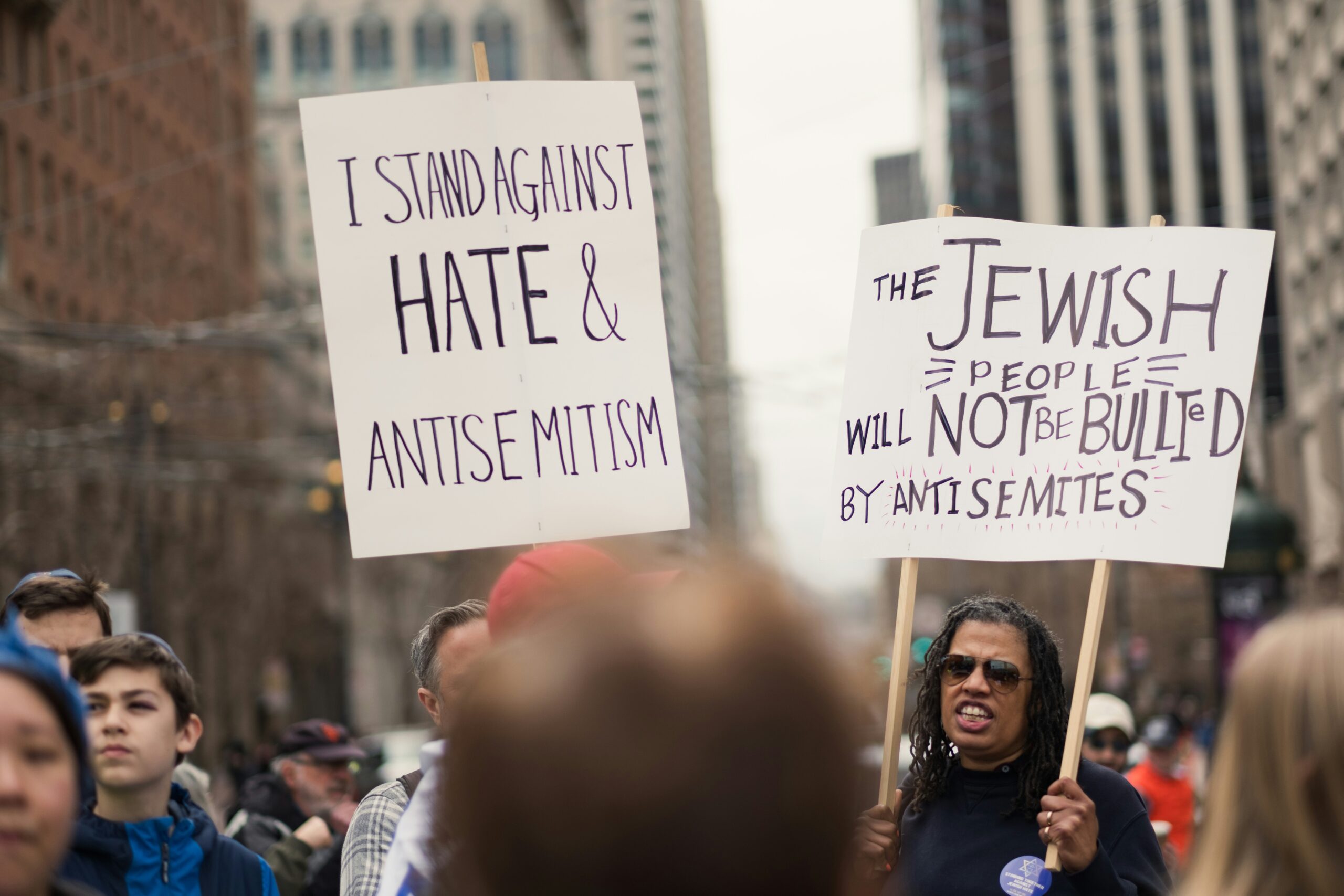 Protest sign reading "Stop Antisemitism" held during a public demonstration, photo by Levi Meir Clancy